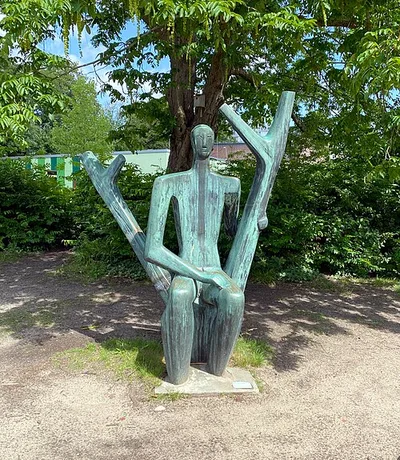 Männliche Figur im Doppelstamm